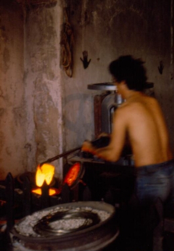 Artisan orfèvre travaillant à son laminoir dans son atelier
